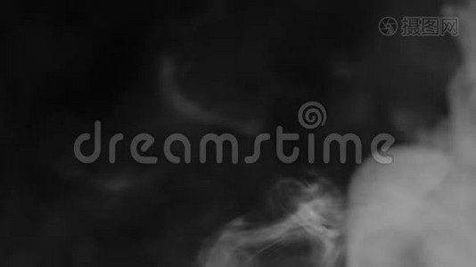 现实的抽象烟雾蒸气效应。 白色烟雾在黑色背景上缓慢运动。 漂浮的雾云笼罩着黑色的背景。视频