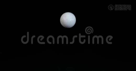 高尔夫`球落在黑色背景下，慢动作视频