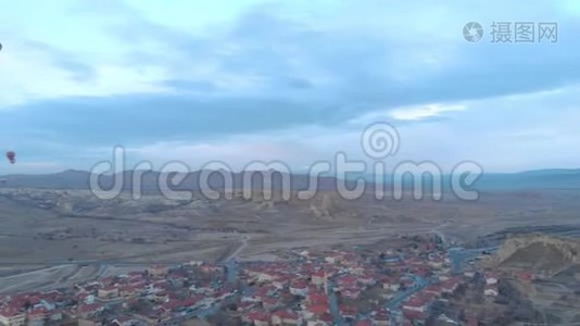土耳其卡帕多西亚日出时，天空晴朗，天空中有许多热气球的空中山谷景观视频