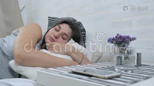 一个怀孕的女孩睡在床上，被手机分心。 怀孕女孩的梦想视频