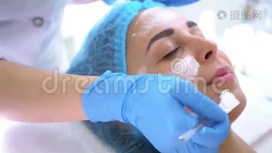 专业美容师和皮肤科医生在美容院用面膜敷脸。 紧缩和调整程序视频