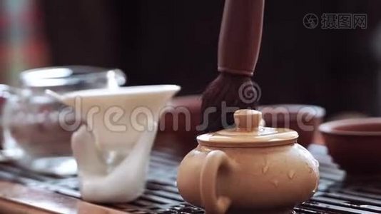 中国的茶道，用茶刷把一个小水壶从滚烫的茶滴中擦去视频