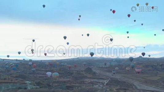 土耳其卡帕多西亚日出时，天空晴朗，天空中有许多热气球的空中山谷景观视频