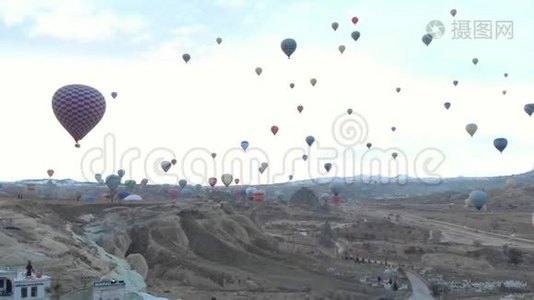 土耳其卡帕多西亚日出时，天空晴朗，天空中有许多热气球的空中山谷景观视频