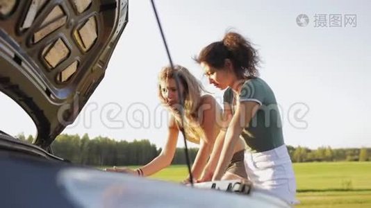 两个穿短裤的性感女孩和一件t恤站在树林里的路上的敞篷汽车前。 那个女孩视频