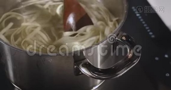 用木勺混合煮面。视频