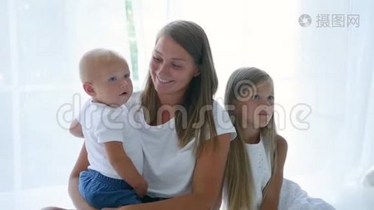 母亲带着儿子和女儿坐在家里反对视频
