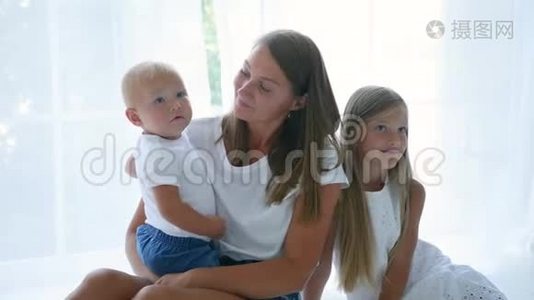 母亲带着儿子和女儿坐在家里反对视频