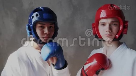 多民族的。 两个勇敢自信的拳击手穿着和服，戴着红蓝相间的手套和防护头盔视频