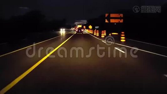 行车道在夜间用施工标志结束乡村道路.. 司机的观点POV橙色警告路标视频