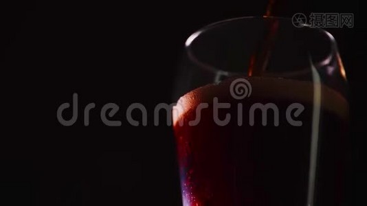 浇筑柯拉慢动作特写.. 杯子里有气泡的可乐。 可乐汽水在黑色背景下特写。 慢动作视频