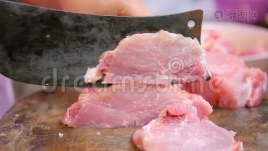 女人的手用菜刀把猪肉切片放在砧板上煮熟视频