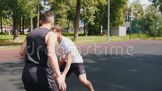 三个运动员在户外的球场上打篮球，一个人把球扔到篮筐上，得分视频