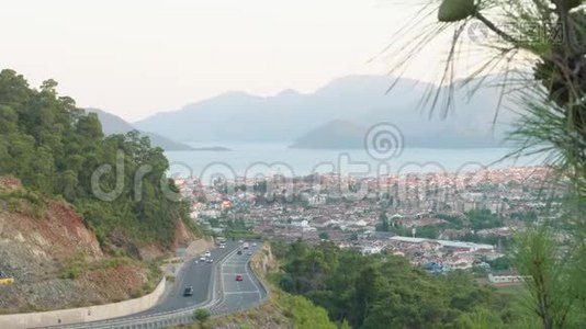 在海上和城市景观上骑在山路上。 蜿蜒曲折的山路、山峦轮廓和蔚蓝的海洋景观视频