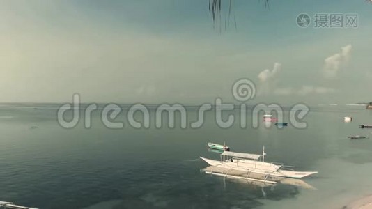 无人机慢慢地在棕榈树之间飞行，用船打开棕榈树林和沙滩上的全景。视频