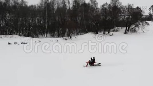 在冰冻的河流上乘雪车的空中景色。 开雪车在白雪上行驶.. 2人乘坐雪车。视频