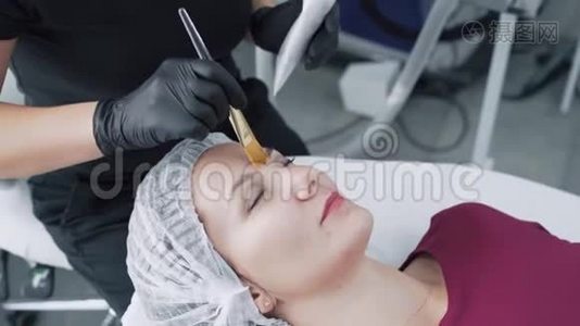 贴身美容师将黑碳面膜敷于女性面部，动作缓慢视频