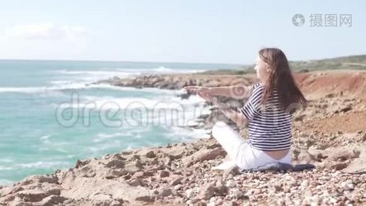 在海边岩石上美丽的地方做体操的游客视频