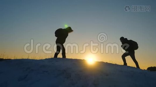 登山者在雪山顶上相遇，享受他们的成功，举起手，快乐地跳跃。 团队合作视频