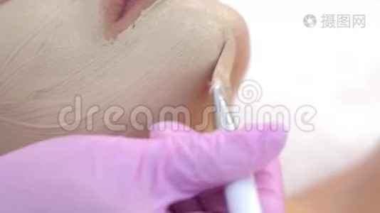 美容医生在美容诊所为女性客户面部敷面膜。视频