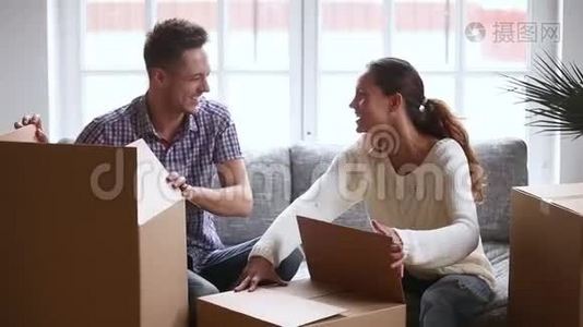 快乐的年轻夫妇笑着打开纸板箱打开纸板箱视频