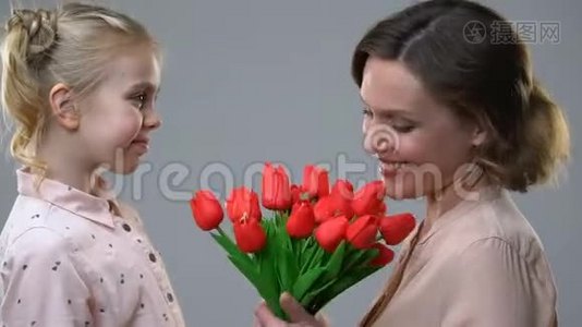 可爱的女孩送花给心爱的母亲，生日惊喜或三月八日视频