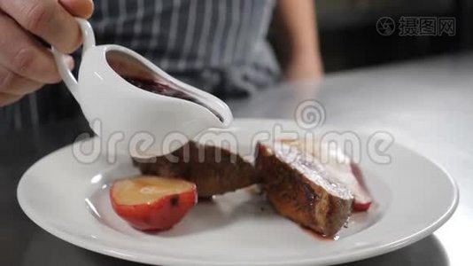 厨师将牛莓酱倒在炸鸭肉上，配上美味的红梨甜点，用干酒煮熟。 餐厅视频