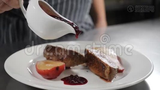 食物录像。 厨师在烤鸭肉上倒入深色酱汁，在白色盘子上配上红梨甜点。 慢动作。 关门视频