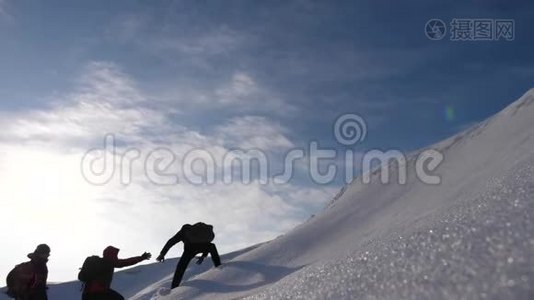 团队合作渴望获胜。 登山者互相`帮助朋友爬上雪山。 旅行者视频