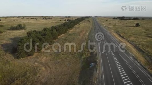 从空中俯瞰穿过田野的公路。视频