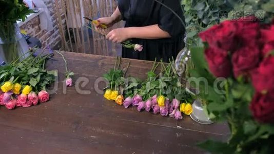 花商妇女准备花束剪玫瑰刺在商店，特写。视频
