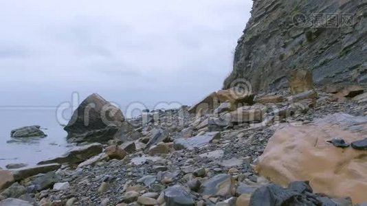 海岸雨天有巨大悬崖的野生石滩。视频
