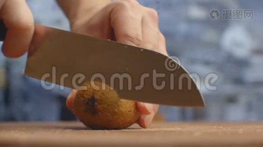 在厨房里用一把刀切在木板上特写猕猴桃.. 切碎。视频
