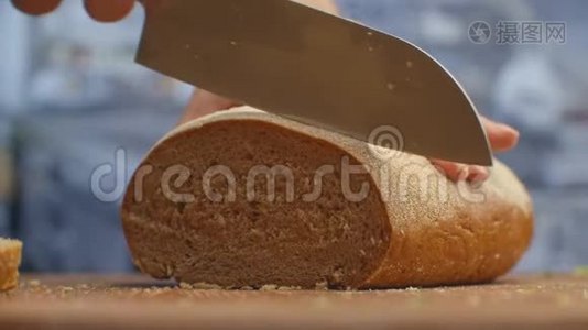 在厨房的木板特写上用刀切面包。 切碎。视频
