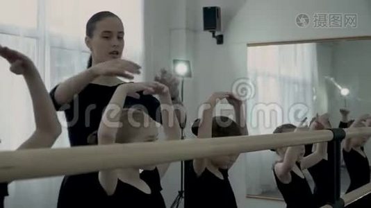 舞蹈班严格的女老师纠正小芭蕾舞演员的位置，教她们如何保持双手靠近视频