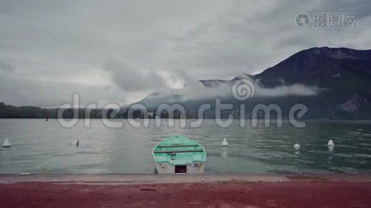雨天雾山背景下，孤独的薄荷船停泊在安纳西湖的长廊上视频