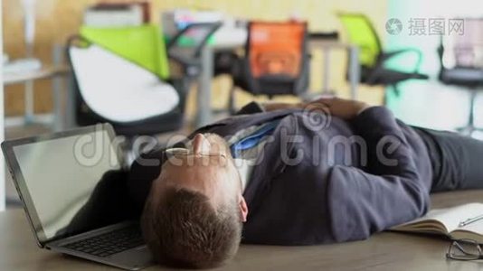 疲惫的时尚工人睡在办公室的桌子上视频