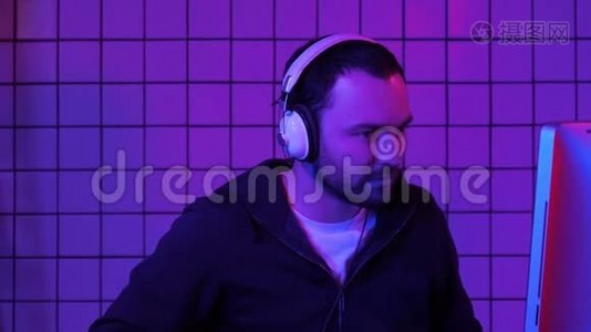 快乐的玩家在电脑上玩电子游戏，并显示拇指到相机。视频