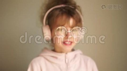 女孩用耳机听音乐和跳舞，青年爱好，美洛曼尼亚。戴着耳机的少女画像视频