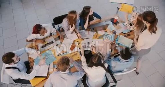 顶视幸福商务女性老板一起工作，分析财务数据与年轻的公司员工在会议上。视频