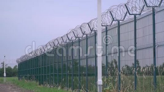 带刺铁丝网的监狱栅栏，又长又高的绿色栅栏视频