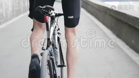 瘦小的骑自行车的腿与强壮的肌肉踏板上坡从马鞍。 骑自行车训练上坡。 自行车的概念。 行动缓慢视频