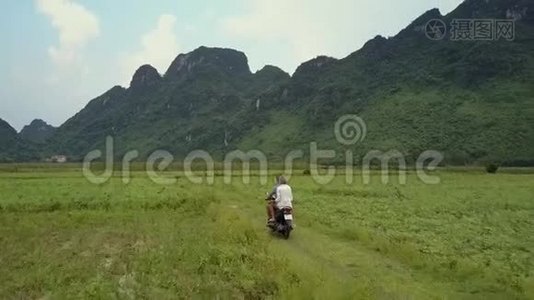 女孩骑滑板车沿着农田鸟瞰视频