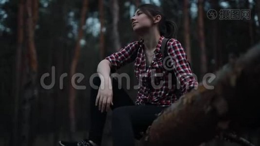 疲惫而快乐的女人坐在森林的树干上放松视频
