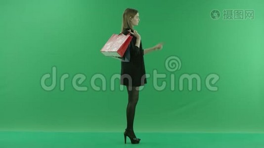 带包的迷人年轻女性使用增强现实购物，彩色钥匙绿色背景视频