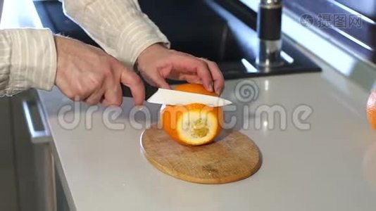 男手在厨房里切鲜橙色。 慢动作。 特写镜头。视频