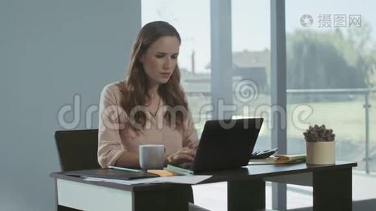 女商人收到坏消息。 在笔记本电脑上工作的严肃自由职业女性。视频