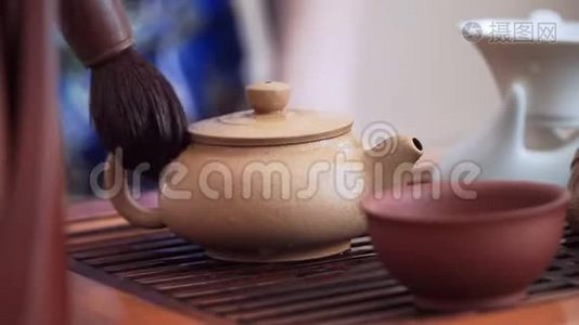 用特制的茶刷把水壶从热滴中擦干净视频