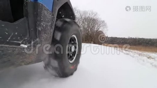 一辆并排的ATV在雪地里的乡村道路上行驶。视频