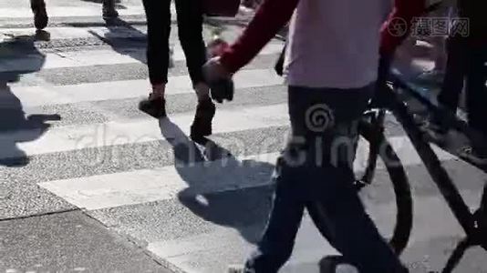 在人行横道上行走的人群的腿。人群脚的特写镜头。城市人群。视频